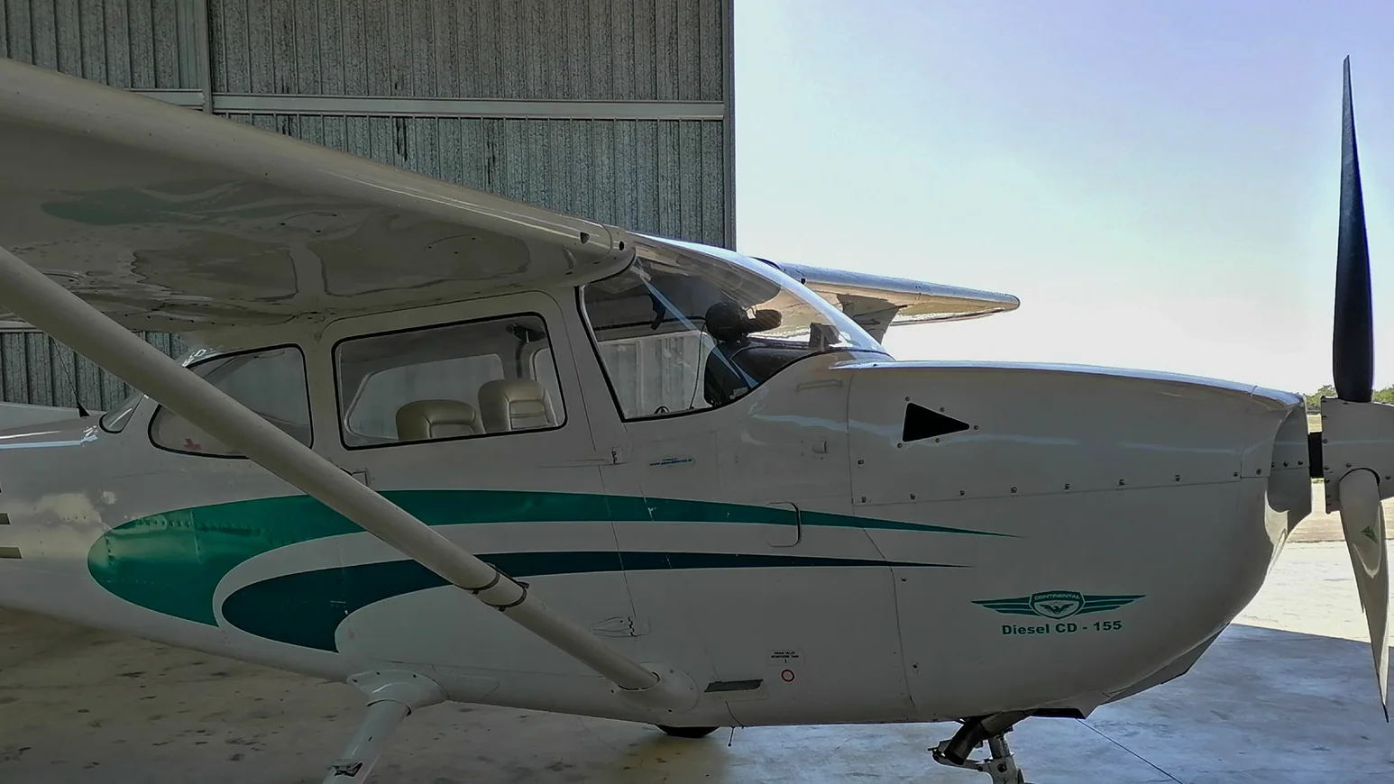 Single-engine training aircraft parked inside a maintenance hangar